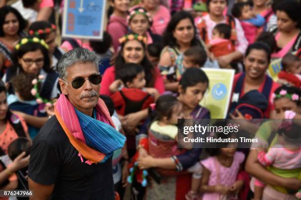 Actor and model Milind Soman and Women with their babies participate in Baby-Wearing Super Moms event organised by by Colors Pinkathon at Juhu Beach,...