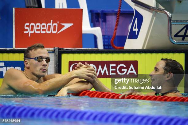 Yauhen Tsurkin congratulates Chad Le Clos of South Africa after he wins the men's 100m Butterfly final during the FINA Swimming World Cup at OCBC...