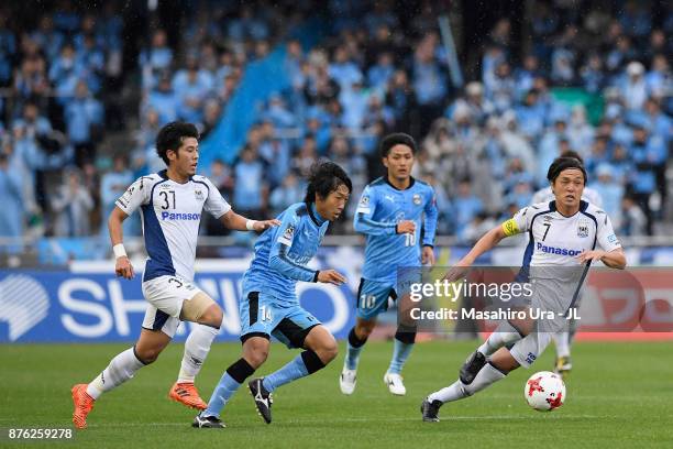 Kengo Nakamura of Kawasaki Frontale competes for the ball against Akito Takagi and Yasuhito Endo of Gamba Osaka during the J.League J1 match between...