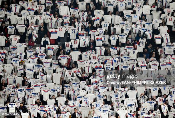 Lyon's fans display the jerseys of their team's various players as they cheer during the French L1 football match Lyon vs Montpellier on November 19,...