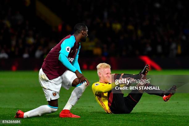 Watford's English midfielder Will Hughes holds his leg after being fouled by West Ham United's Spanish midfielder Pedro Obiang , an offence for which...