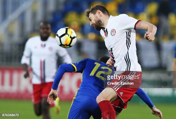 Aleksei Ionov of FC Rostov Rostov-on-Don vies for the ball with Mikhail Sivakow of FC Amkar Perm during the Russian Premier League match between FC...