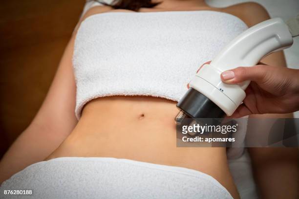 cavitation for cellulite treatment on young woman abdomen - cellulite concept stock pictures, royalty-free photos & images