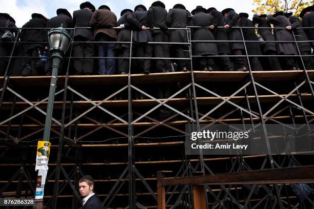 Child walks under the scaffold as Hasidic rabbis prepare to pose a group photo, part of the annual International Conference of Chabad-Lubavitch...