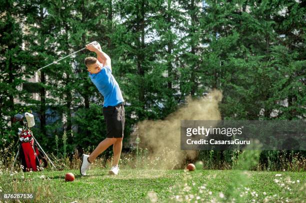 young golfer teeing off on the golf course - swinging golf club stock pictures, royalty-free photos & images
