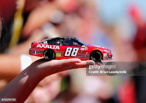 Fan holds out a model of the car of Dale Earnhardt Jr., driver of the AXALTA Chevrolet, to be autographed prior to the driver's meeting for the...