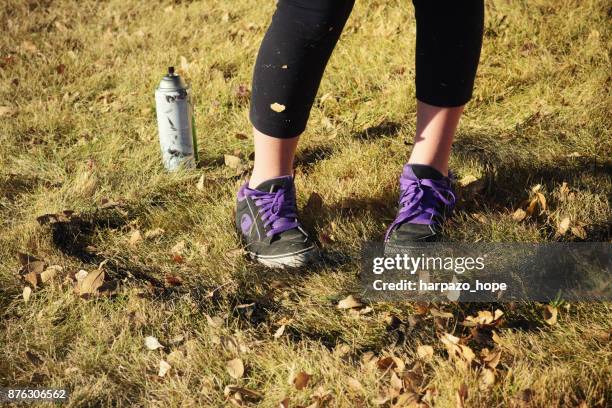 girl's feet and a can of spray paint. - harpazo hope stock pictures, royalty-free photos & images