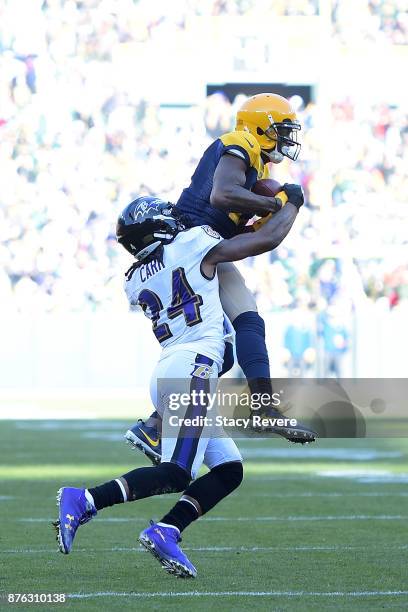 Davante Adams of the Green Bay Packers catches a pass in front of Brandon Carr of the Baltimore Ravens during the first half at Lambeau Field on...