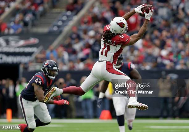 Larry Fitzgerald of the Arizona Cardinals catches a pass in the second quarter defended by Jelani Jenkins of the Houston Texans at NRG Stadium on...