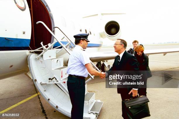 Bundesfinanzminister Hans Eichel mit Aktentasche an der Gangway eines Flugzeugs. .
