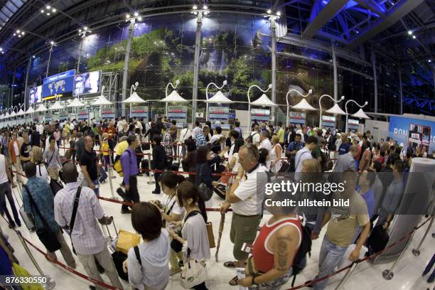 Passagiere warten in einer ueberfuellten Halle auf die Passkontrolle thailaendischer Beamter, um den Abflugbereich des Flughafens Bangkok erreichen...