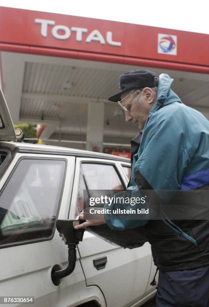 Autofahrer füllt aus einem Reservekanister Benzin in den Tank seines Autos - 2003 Nur-für-redaktionelle-Zwecke!
