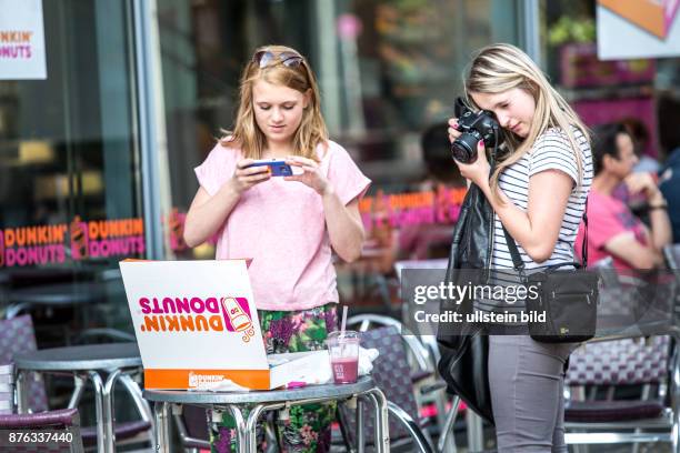 Deutschland Germany Berlin Mädchen fotografieren eine gerade gekaufte Schachtel mit Donuts vor einer Filliale von Dunkin Donuts am Potsdamer Platz.