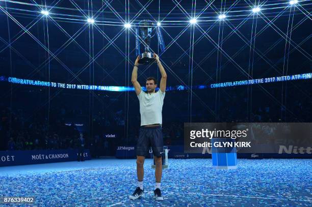 Bulgaria's Grigor Dimitrov holds the trophy as he celebrates winning his men's singles final match against Belgium's David Goffin on day eight of the...