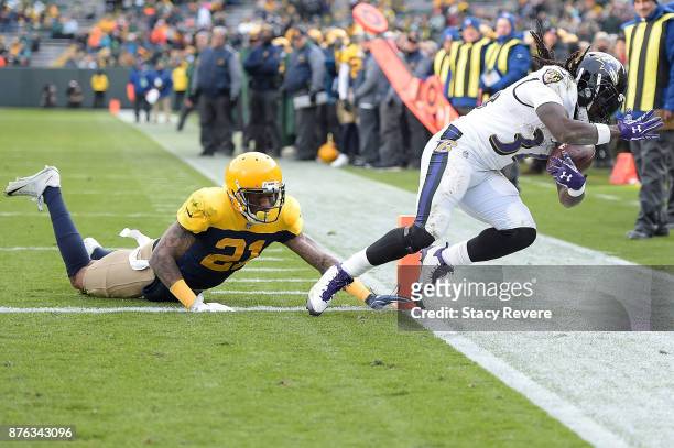 Alex Collins of the Baltimore Ravens rushes for a touchdown after avoiding a tackle by Ha Ha Clinton-Dix of the Green Bay Packers during the second...