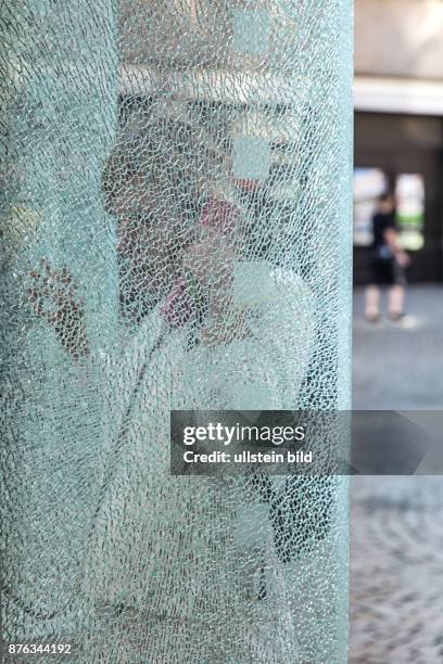 Deutschland Germany Berlin Frau telefoniert an einer Telefonzelle mit gesplittertem Glas in Berlin-Spandau.