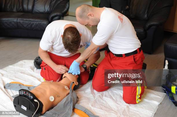 Feuerwehrmänner auf der Feuerwache Prenzlauer Berg bem Üben im Umgang mit einem Defibrillator