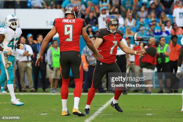 Patrick Murray celebrates with Bryan Anger of the Tampa Bay Buccaneers after kicking the game winning field goal during the fourth quarter against...