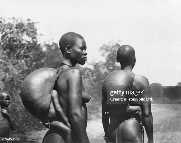 Sudan, Acholi people, women carrying their babies on the back, protecting them with pumpkin shells against the sun Photographer: Norbert Jacques...