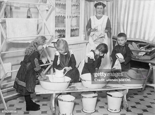 Kindergärtnerin und Kinder beim Geschirrspülen im Pestalozzi-Fröbelhaus in Berlin, Institut mit Säuglingskrippen, Volkskindergärten,...