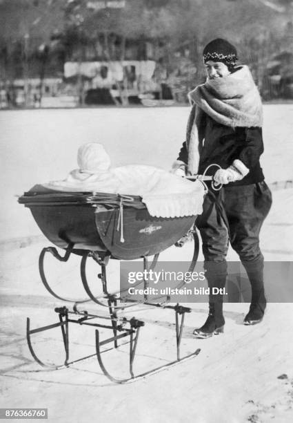 Woman with her baby in a slide pram Vintage property of ullstein bild