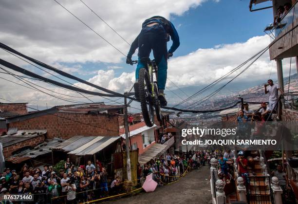 Residents watch as a downhill rider competes during the Urban Bike Inder Medellin race final at the Comuna 1 shantytown in Medellin, Antioquia...