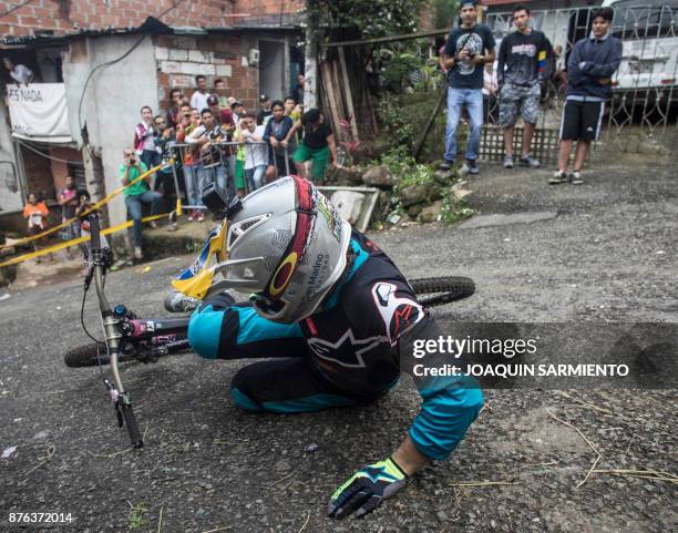 Residents look at a downhill rider during the Urban Bike Inder Medellin race final at the Comuna 1 shantytown in Medellin, Antioquia department,...