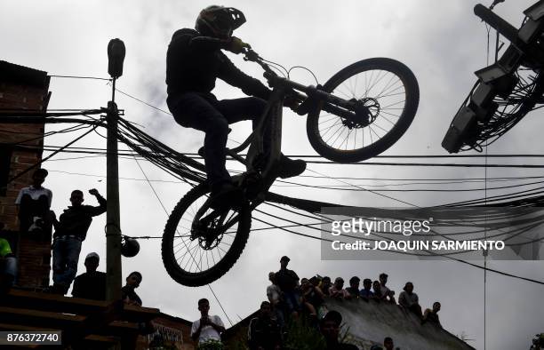 People look at a downhill rider during the Urban Bike Inder Medellin race final at the Comuna 1 shantytown in Medellin, Antioquia department,...