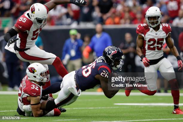 Lamar Miller of the Houston Texans is tackled by Tyrann Mathieu of the Arizona Cardinals in the second quarter at NRG Stadium on November 19, 2017 in...
