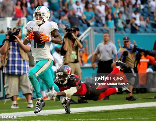 Miami Dolphins' Kenny Stills catches a pass and runs for a fourth quarter touchdown as Tampa Bay Buccaneers' Justin Evans fails to stop him on...