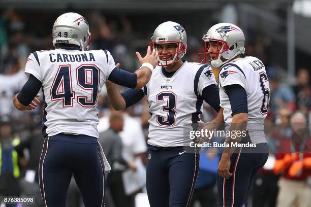 Stephen Gostkowski of the New England Patriots celebrates with Joe Cardona and Ryan Allen after kicking a field goal against the Oakland Raiders...