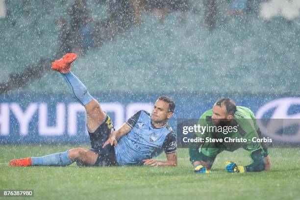 Deyvison Rogério da Silva, Bobô of the Sydney FC lands next to Jets goalkeeper Jack Duncan in the pouring rain during the round seven A-League match...