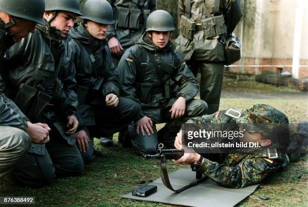 Soldaten bei der Grundausbildung der Bundeswehr. Ein Ausbilder erklärt Wehrpflichtigen die Handhabung eines G 3.