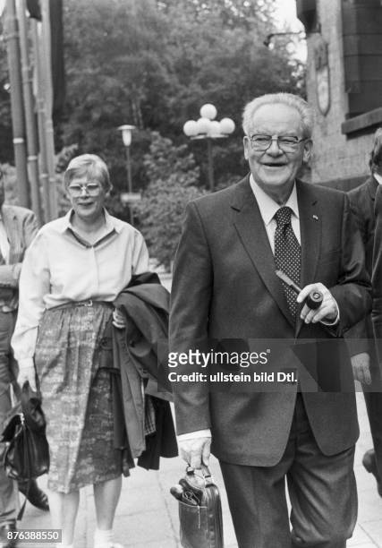 Herbert Wehner, Politiker der SPD, mit Pfeife und Aktentasche. Im Hintergrund seine dritte Ehefrau Greta. Aufgenommen um 1984.