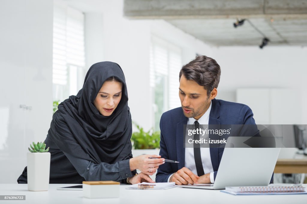 Businessman and muslim businesswoman working on project