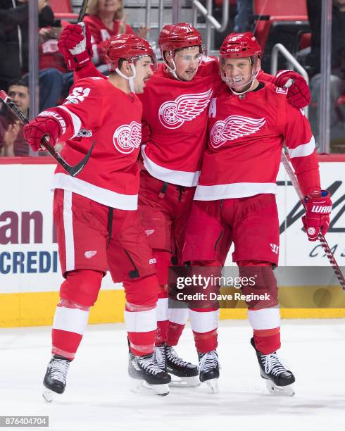 Justin Abdelkader of the Detroit Red Wings celebrates his first period goal with teammates Xavier Ouellet and Dylan Larkin during an NHL game against...