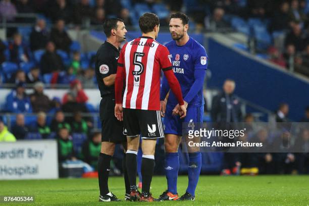 Referee Andy Madley calms both Sean Morrison of Cardiff City and Andreas Bjelland of Brentford after an altercation during the Sky Bet Championship...
