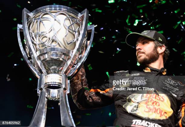 Martin Truex Jr., driver of the Bass Pro Shops/Tracker Boats Toyota, celebrates with the trophy in Victory Lane after winning the Monster Energy...