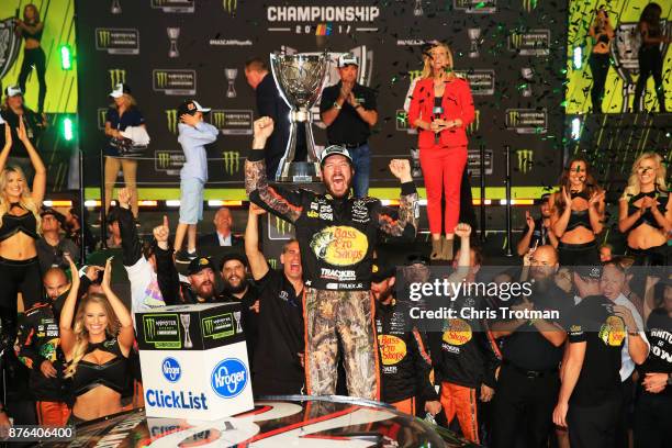Martin Truex Jr., driver of the Bass Pro Shops/Tracker Boats Toyota, celebrates in Victory Lane after winning the Monster Energy NASCAR Cup Series...