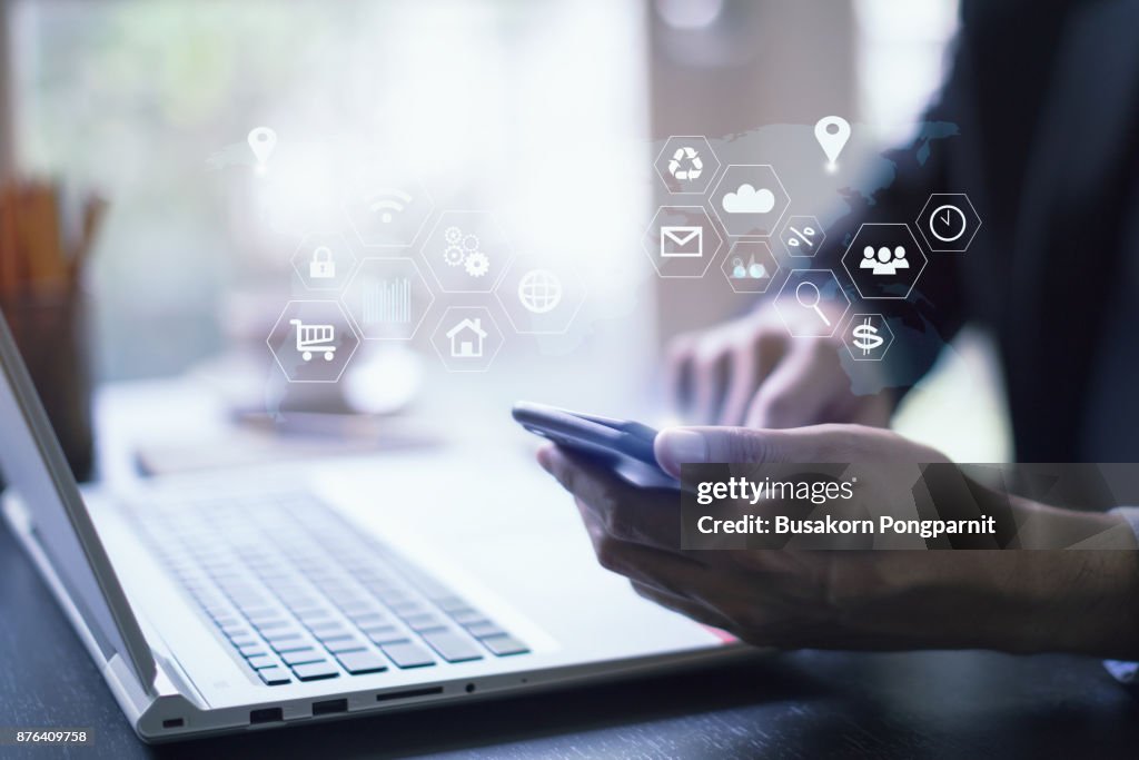 Businessman working with laptop computer and digital tablet and smart phone in modern office with virtual icons interface