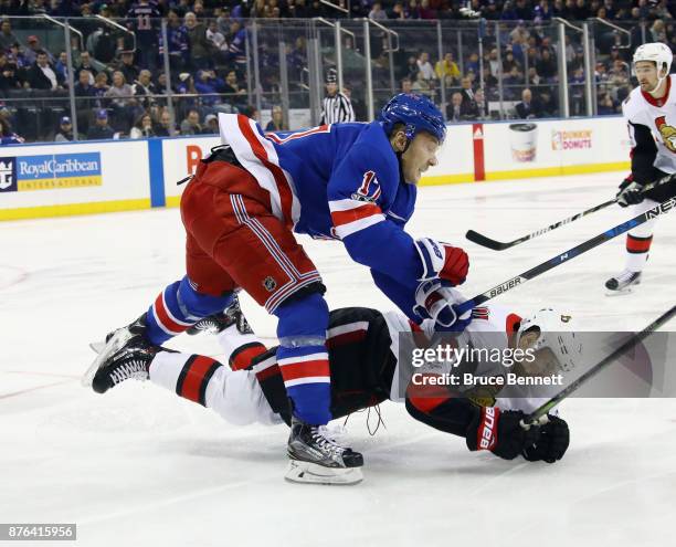 Jesper Fast of the New York Rangers hits Derick Brassard of the Ottawa Senators during the first period at Madison Square Garden on November 19, 2017...