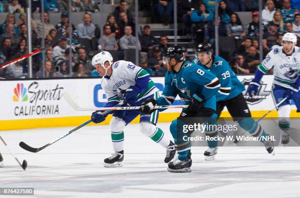 Derek Dorsett of the Vancouver Canucks skates against Joe Pavelski and Logan Couture of the San Jose Sharks at SAP Center on November 11, 2017 in San...