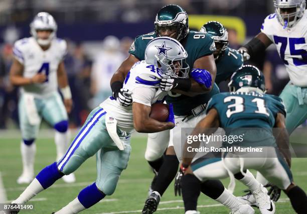 Alfred Morris of the Dallas Cowboys is grabbed by Fletcher Cox of the Philadelphia Eagles as he carries the ball in the first quarter of a football...