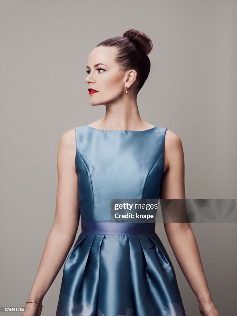 Retro styled woman with make-up red lips and eyeliner in 60s dress