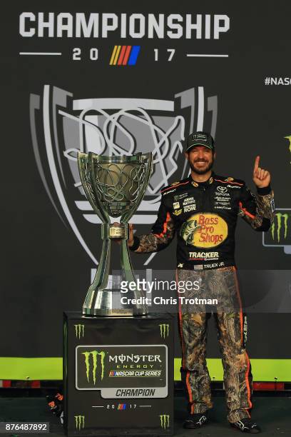 Martin Truex Jr., driver of the Bass Pro Shops/Tracker Boats Toyota, poses with the Monster Energy NASCAR Cup Series championship trophy after...