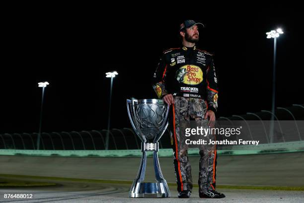 Martin Truex Jr., driver of the Bass Pro Shops/Tracker Boats Toyota, poses with the Monster Energy NASCAR Cup Series championship trophy after...