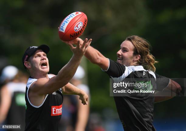 Taylor Adams and Tim Broomhead of the Magpies compete for a mark handballs during a Collingwood Magpies AFL training session at Holden Centre on...