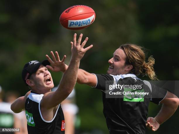 Taylor Adams and Tim Broomhead of the Magpies compete for a mark handballs during a Collingwood Magpies AFL training session at Holden Centre on...