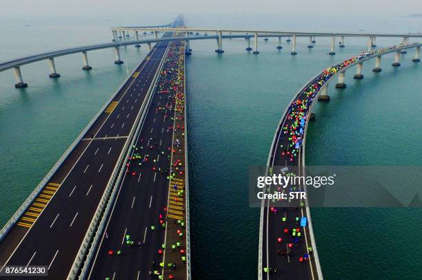 This photo taken on November 19, 2017 shows participants crossing the Jiaozhou Bay Bridge as they compete in the 2017 Qingdao International Marathon...