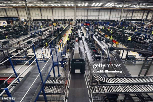 Tote boxes of goods travel on conveyors through the John Lewis Plc customer fulfilment and distribution centre in Milton Keynes, U.K., on Friday,...